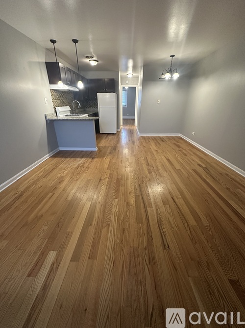 A kitchen area with wooden flooring and a counter.