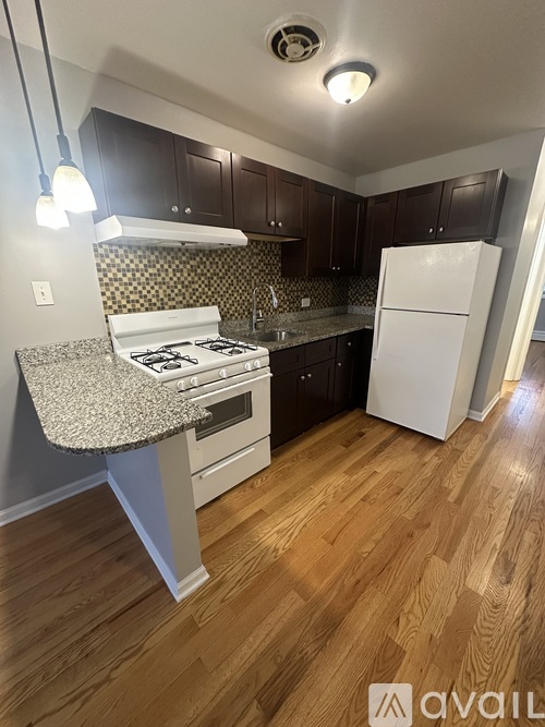 A kitchen with a white stove top oven and a white refrigerator.