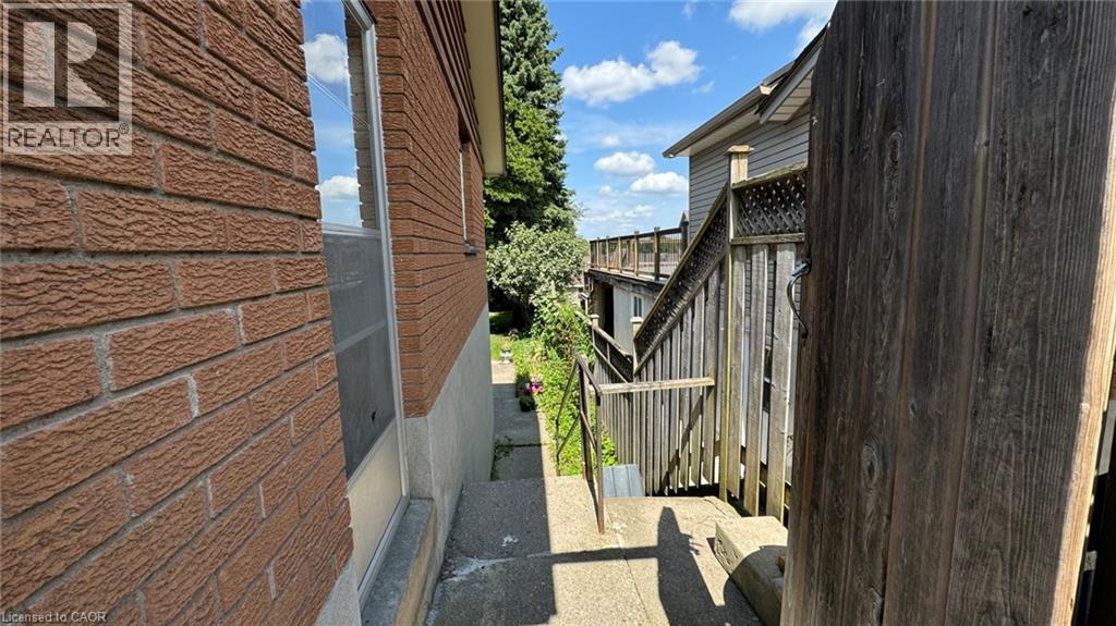 A view of a residential area with a wooden fence and a house with a sign that says "REALTOR".