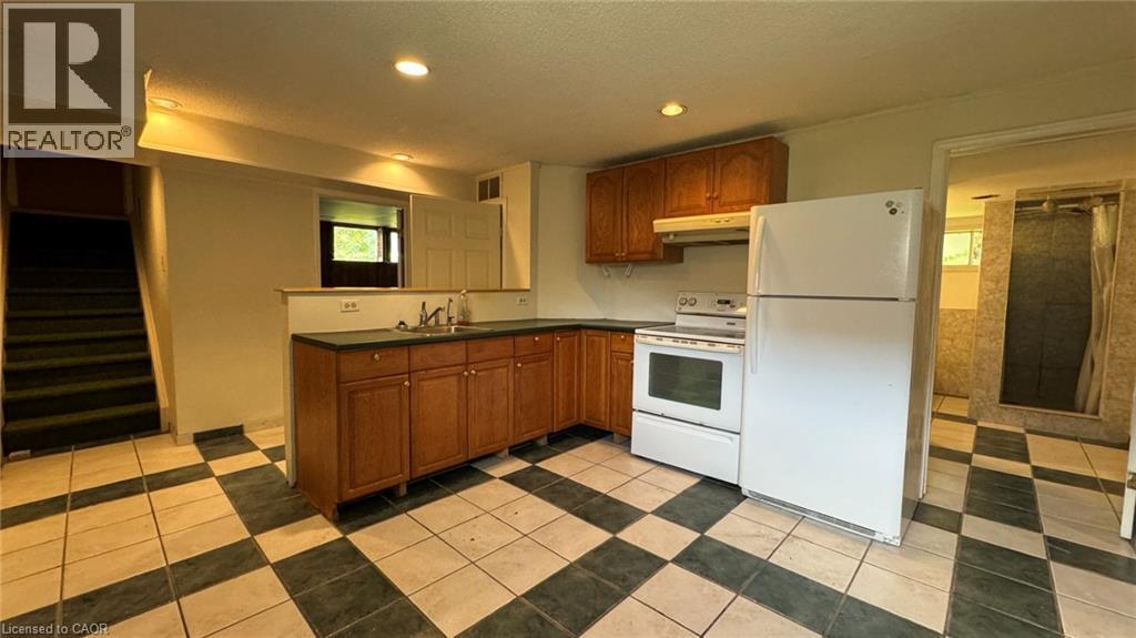 A kitchen with a white fridge and black and white checkered floor.