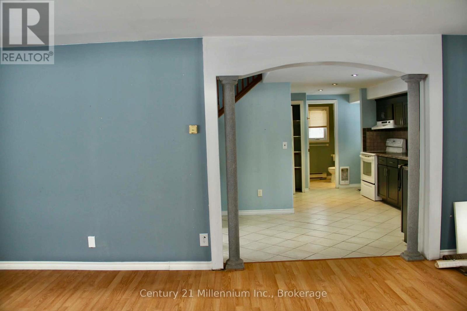 A blue wall with a white archway leading to a kitchen.
