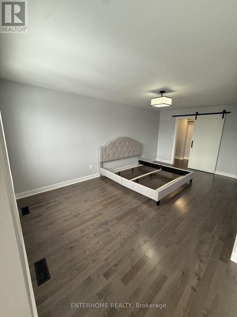 A bedroom with a bed and a wooden floor.