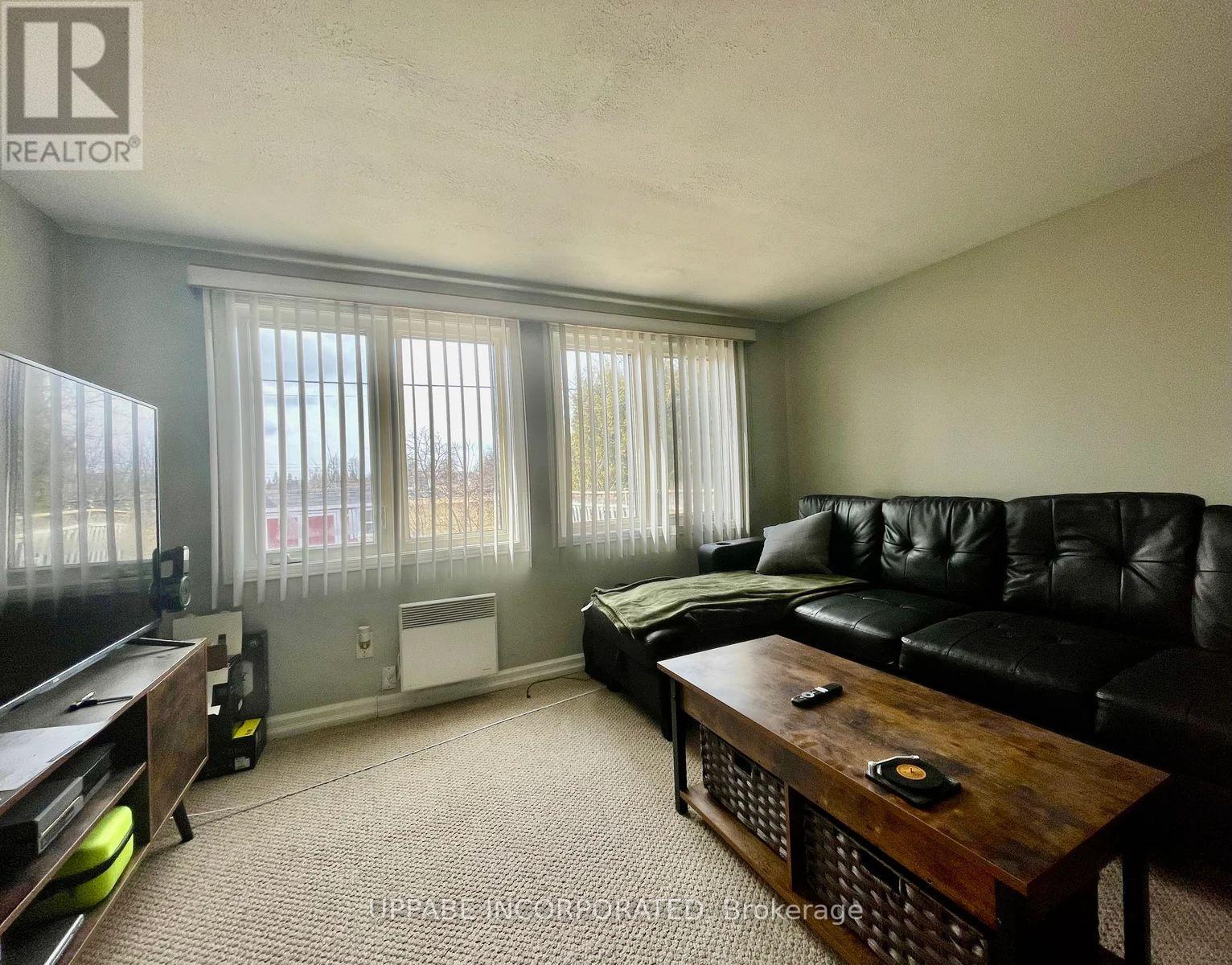 A living room with a black couch and a wooden coffee table.