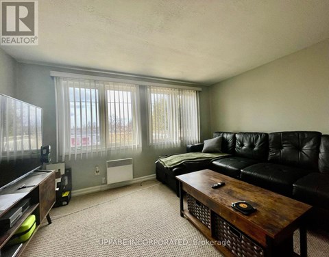 A living room with a black couch and a wooden coffee table.