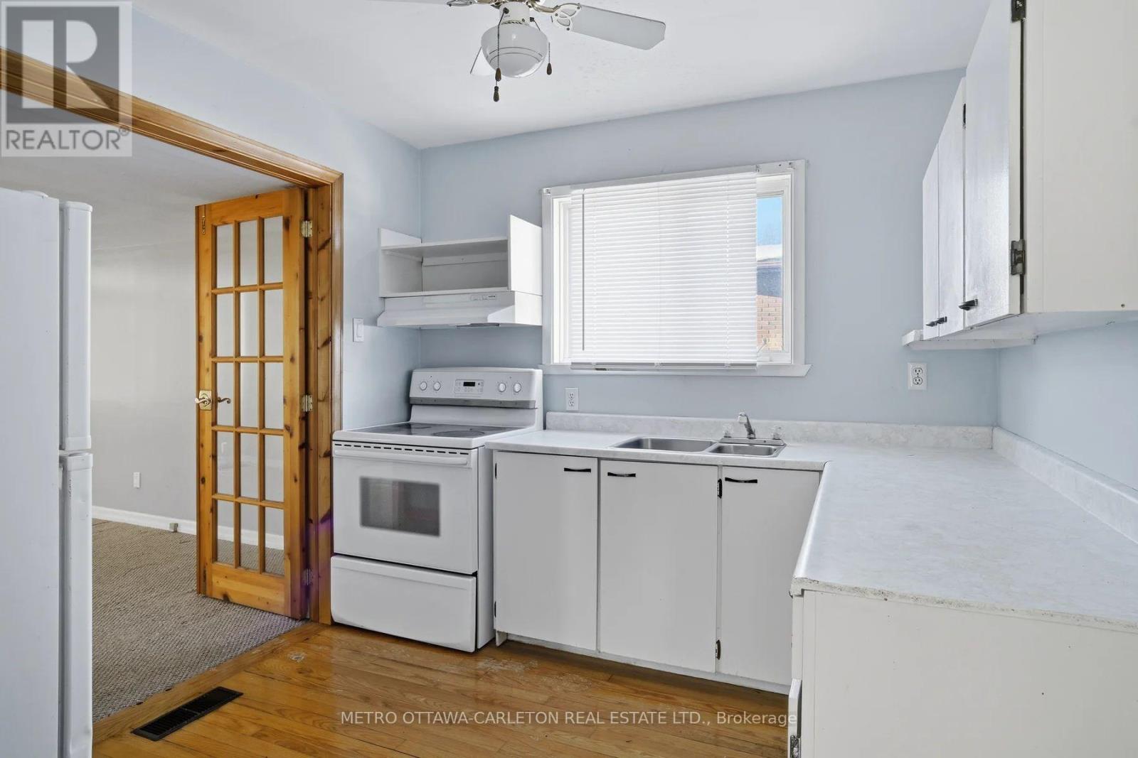 A kitchen with white cabinets and appliances is for sale.
