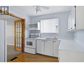 A kitchen with white cabinets and appliances is for sale.