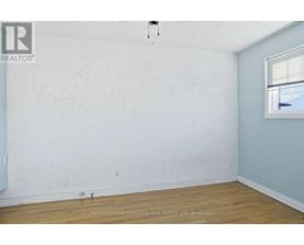 A bedroom with a bed, nightstand, and a dresser with a mirror.