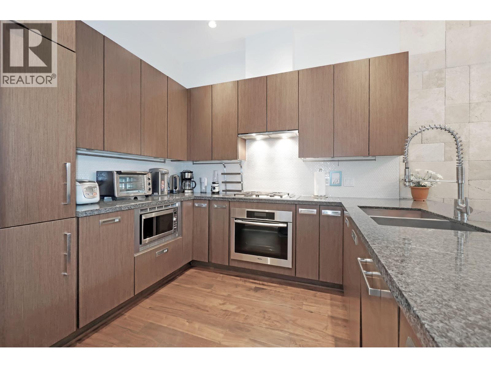 A kitchen with wooden cabinets and granite countertops.