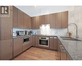 A kitchen with wooden cabinets and granite countertops.