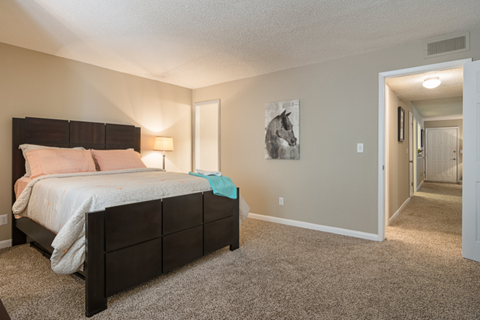 A bedroom with a large bed and a carpeted floor.