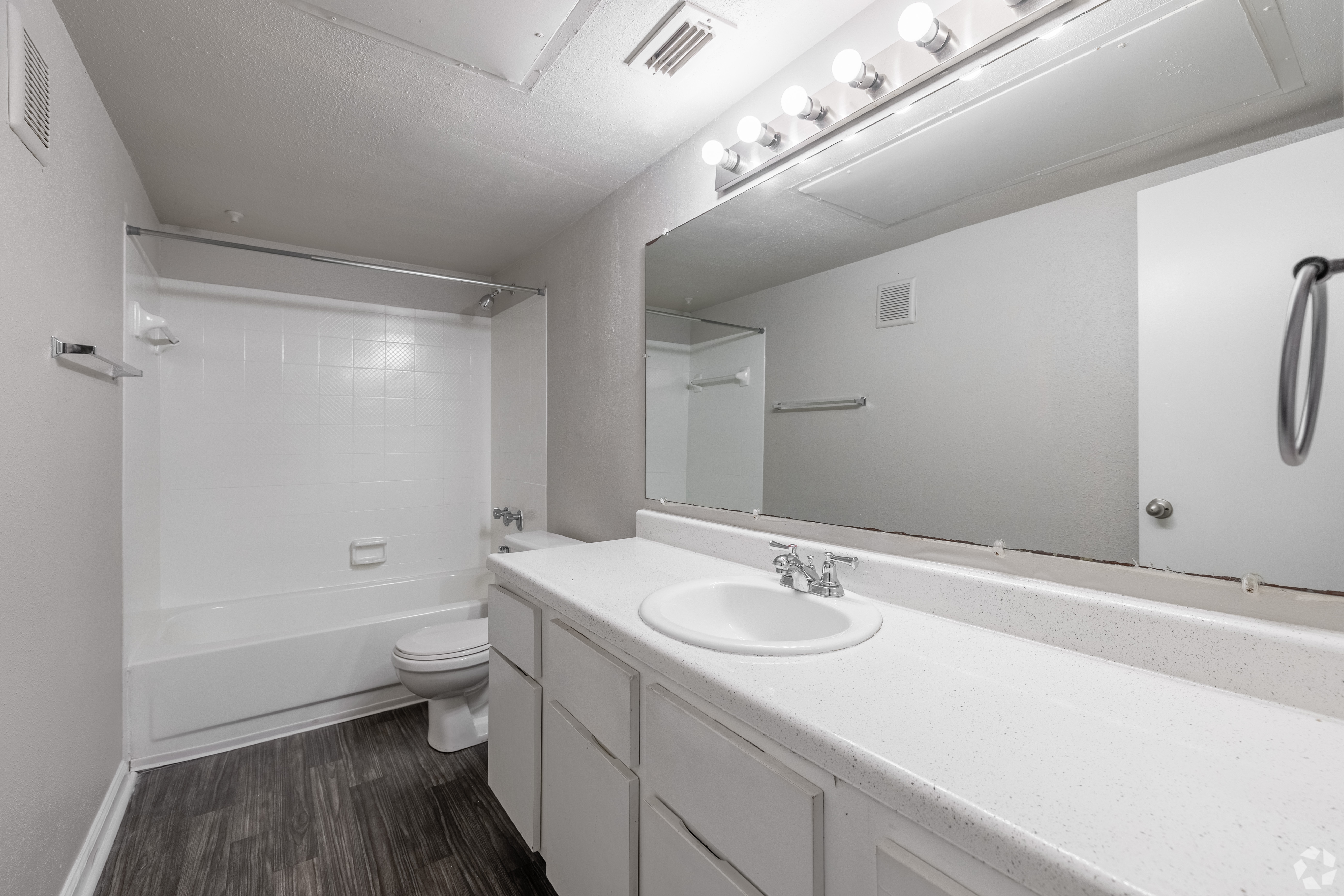 A white bathroom with a toilet, sink, and mirror.