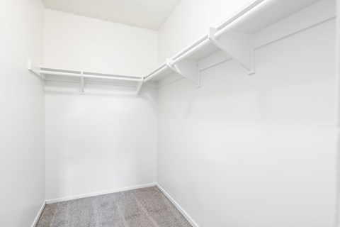 A white room with a carpeted floor and a white wall.