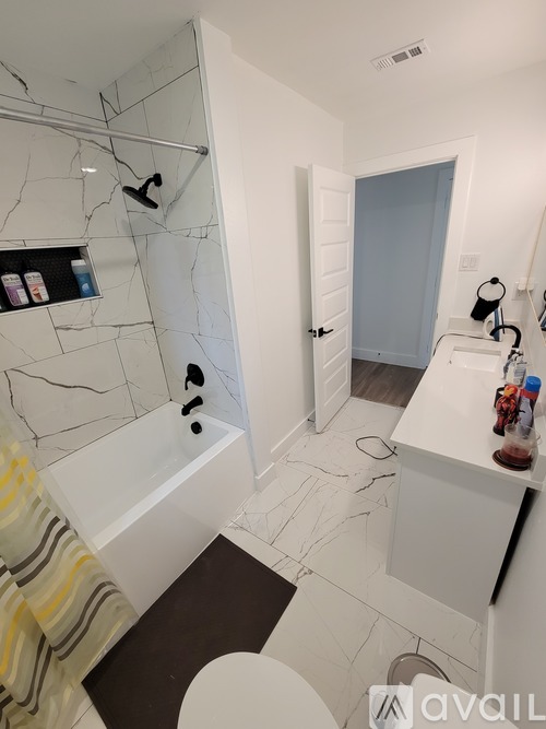 A bathroom with a white tub and a white toilet.