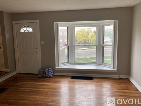 A room with a door and a window with a view of a street.