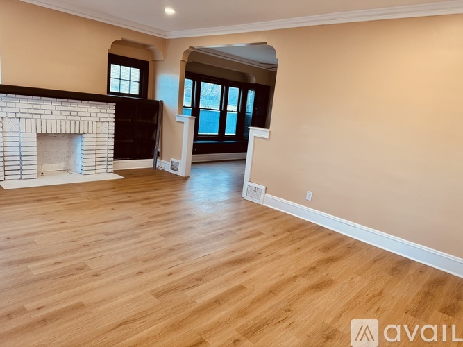 A spacious living room with a fireplace and wooden flooring.