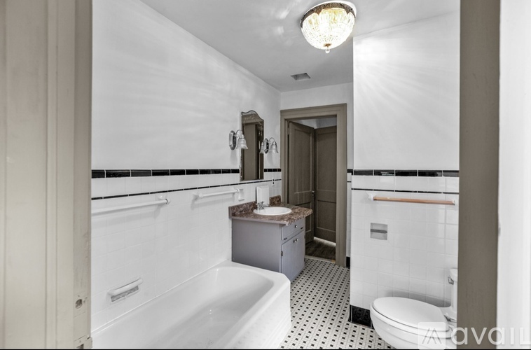 A white bathroom with a black and white tiled floor.