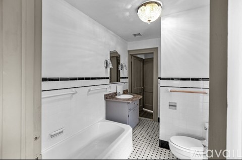 A white bathroom with a black and white tiled floor.
