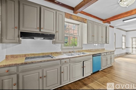 A kitchen with wooden floors and cabinets in a house.