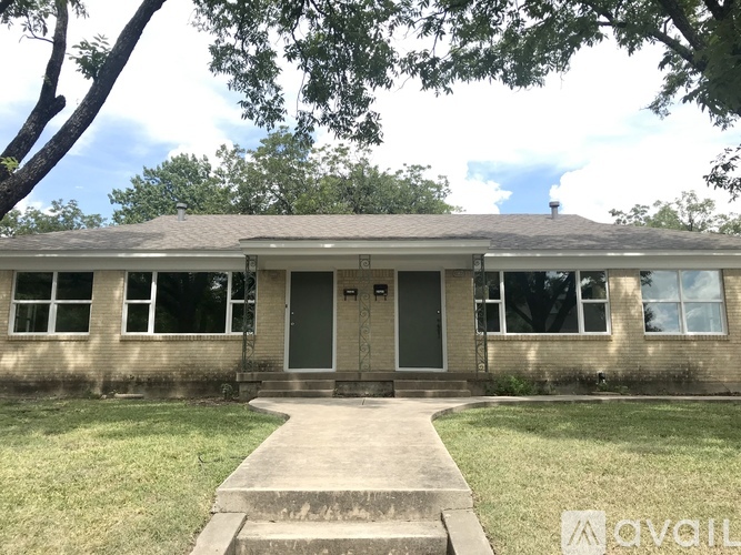 A house with a front yard and a tree in the front.