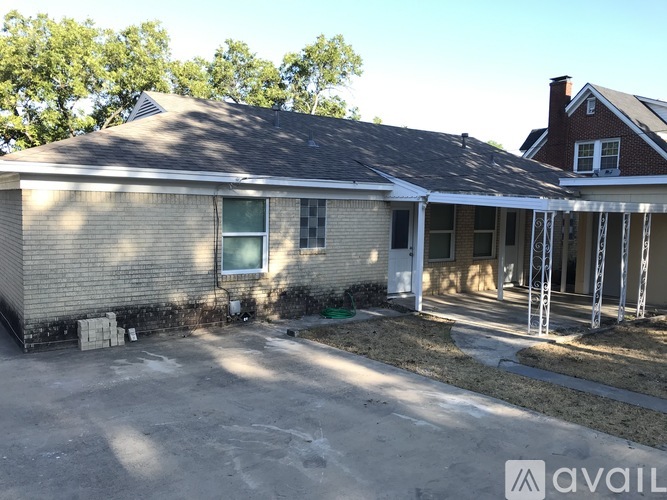 A house with a brick exterior and a covered patio area is for sale.