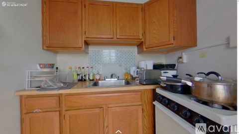 A kitchen with wooden cabinets and a white stove.