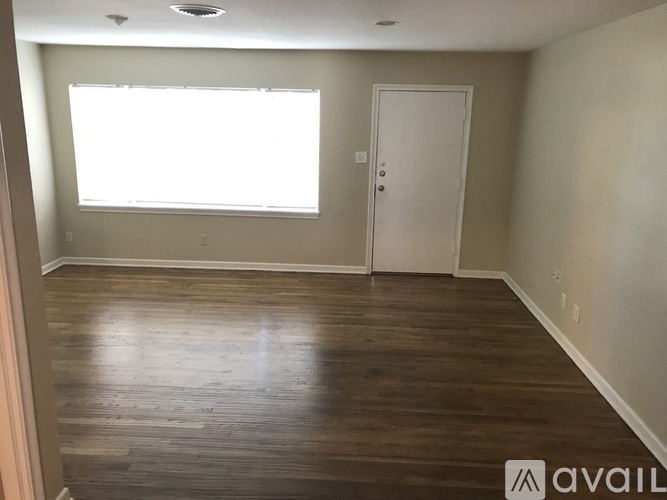 A room with wooden floors and a white door.