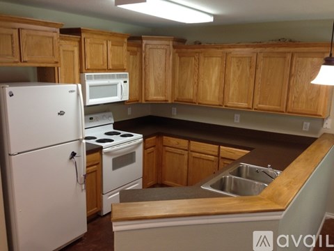 A kitchen with wooden cabinets and a white fridge.