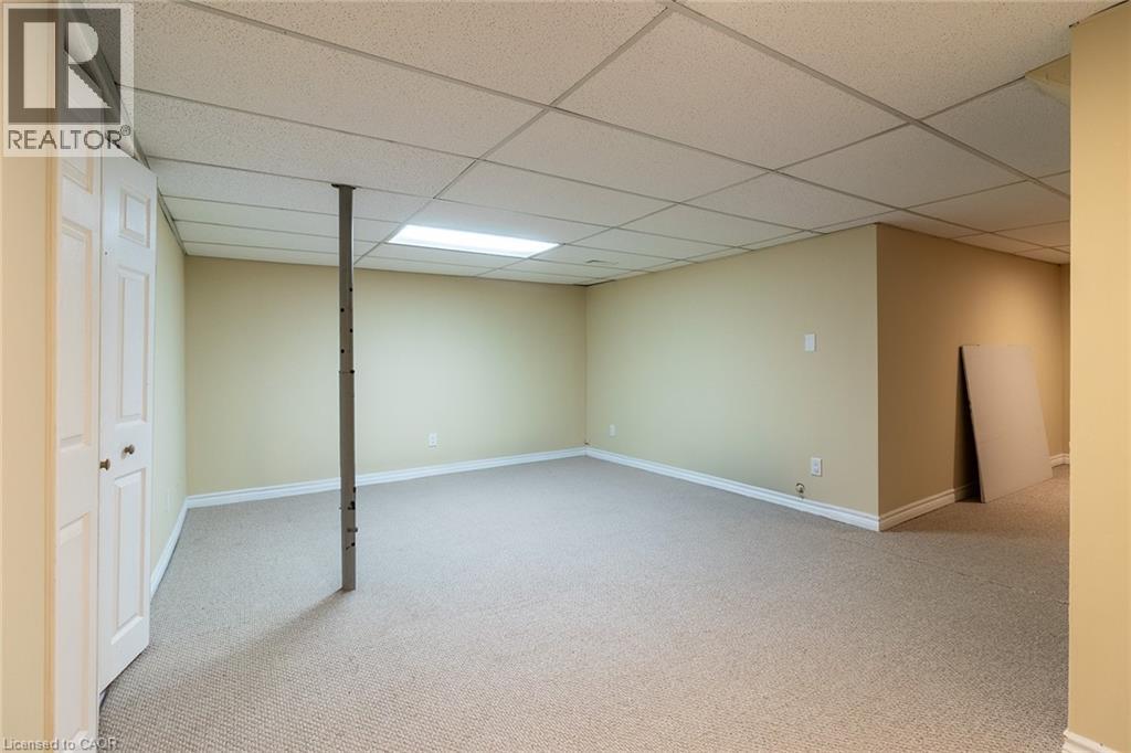 A spacious room with a carpeted floor and a white ceiling with a light fixture.