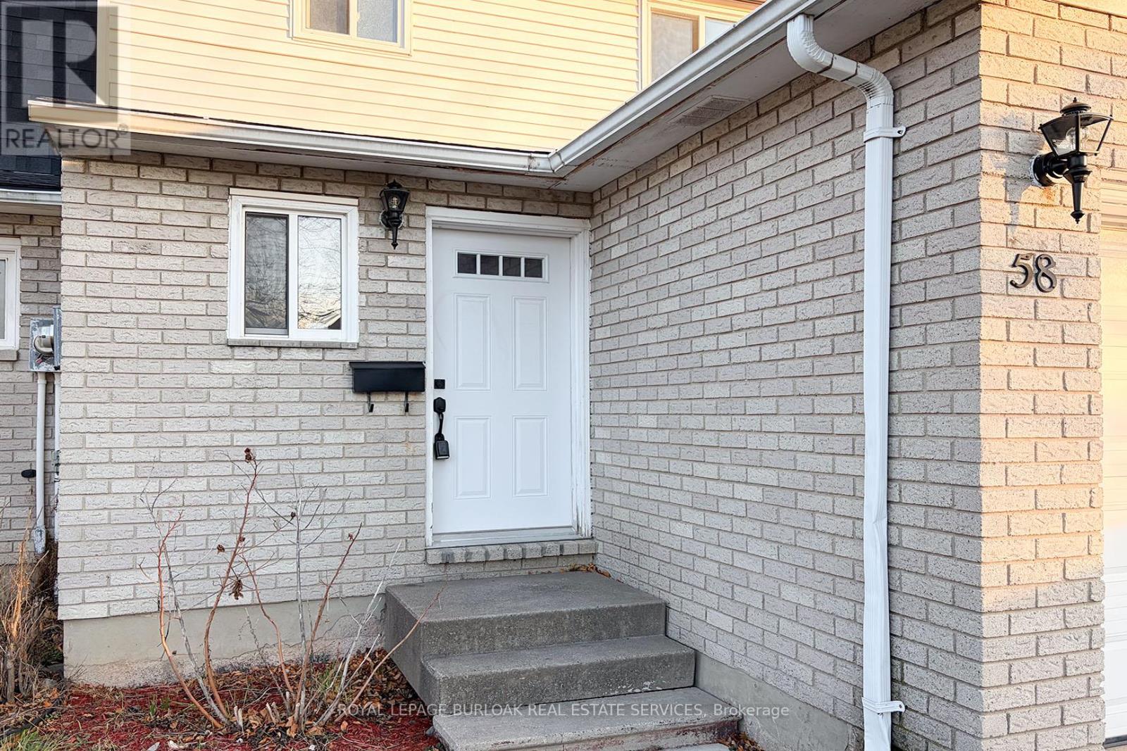 A house with a white door and a sign that says REALTOR.