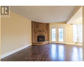A living room with a fireplace and wood flooring.
