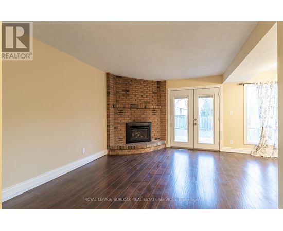 A living room with a fireplace and wood flooring.