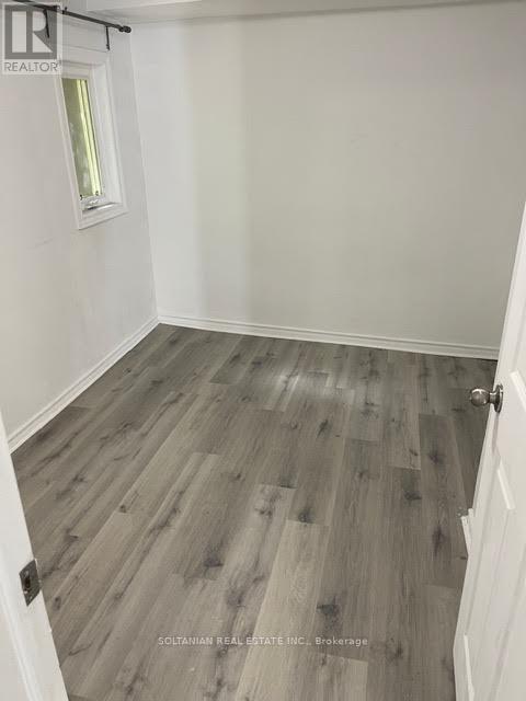 A room with a wooden floor and a white door.