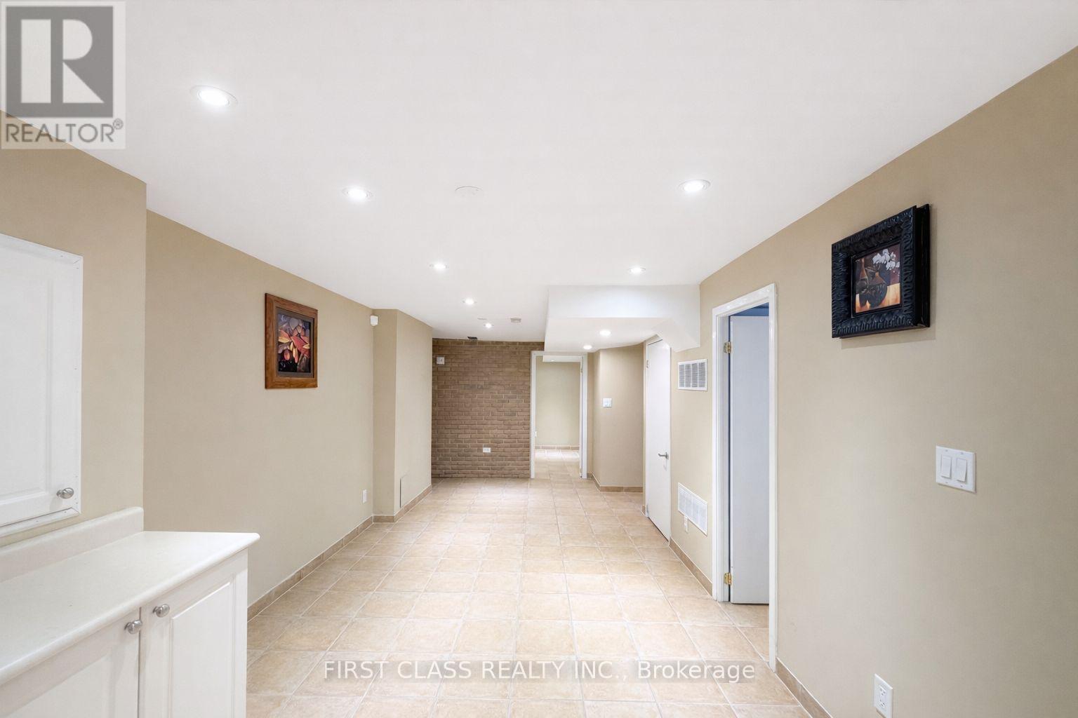 A hallway with a white cabinet on the left and a framed picture on the wall.