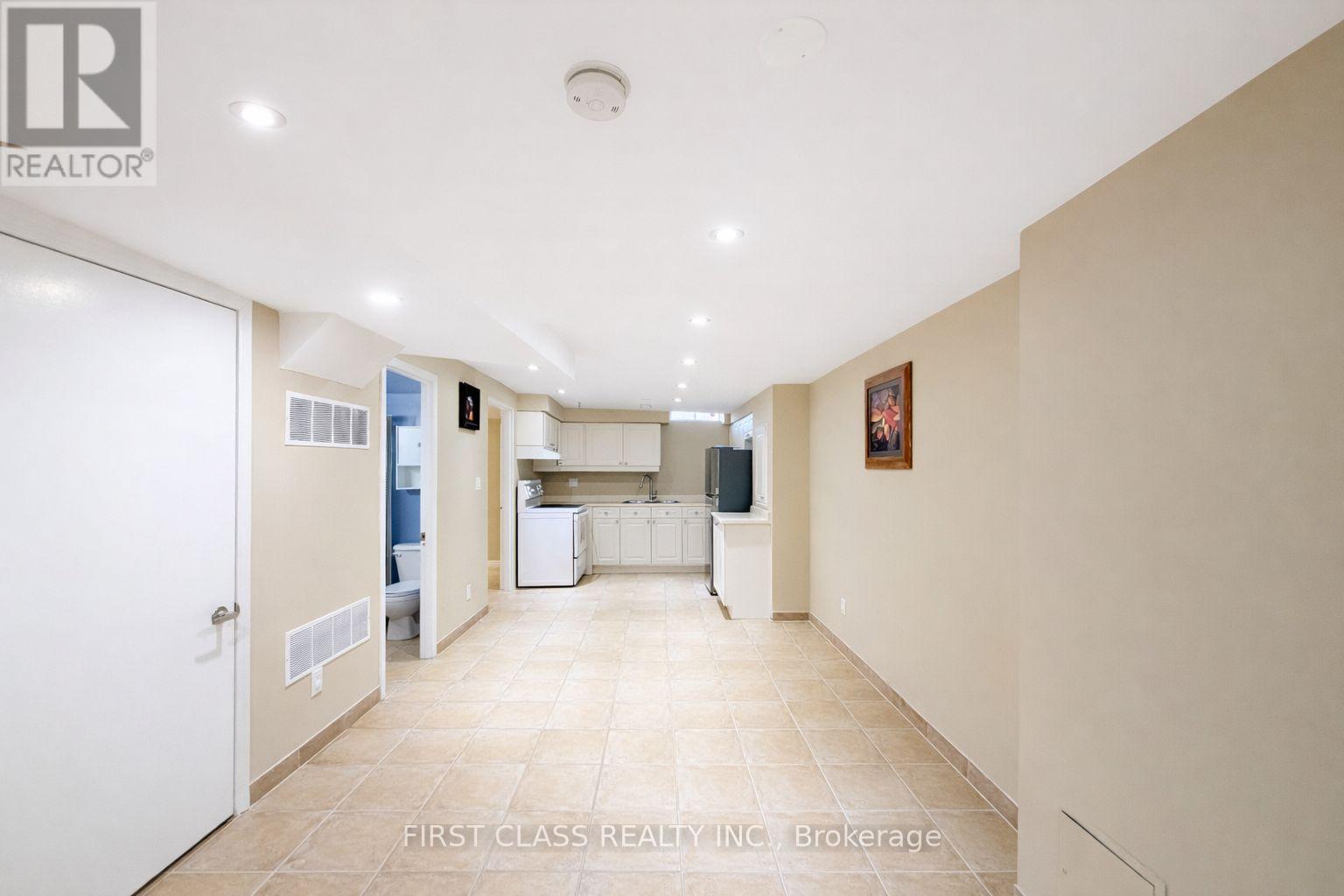 A spacious kitchen and living room with a white door on the left.