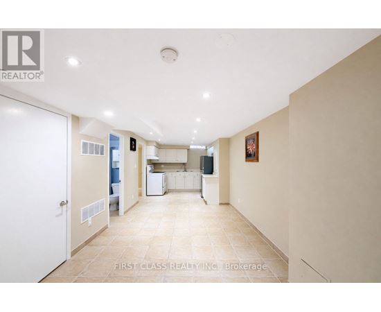 A spacious kitchen and living room with a white door on the left.