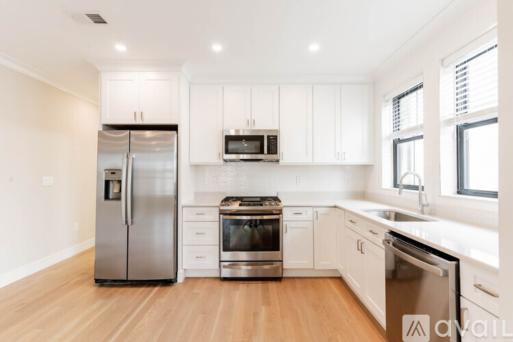 A kitchen with white cabinets and stainless steel appliances.