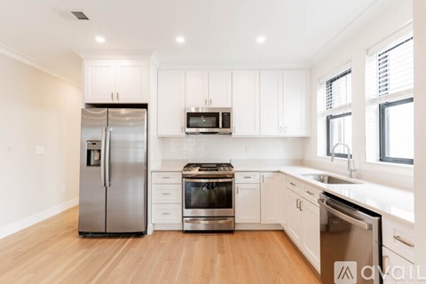 A kitchen with white cabinets and stainless steel appliances.