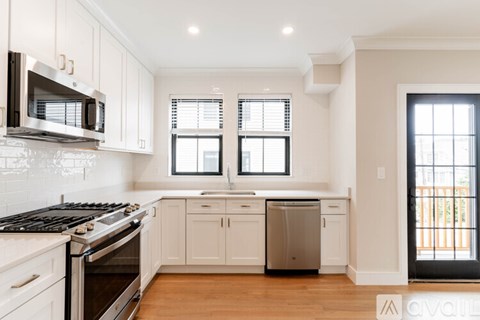 A kitchen with white cabinets and a black stove top oven.