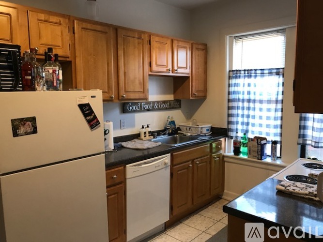 A kitchen with wooden cabinets and a white fridge.