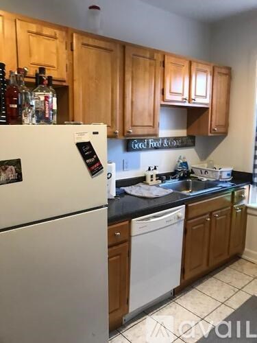 A kitchen with wooden cabinets and a white refrigerator.