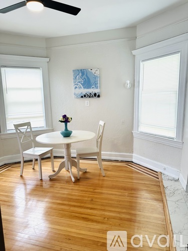 A dining room with a white table and chairs.