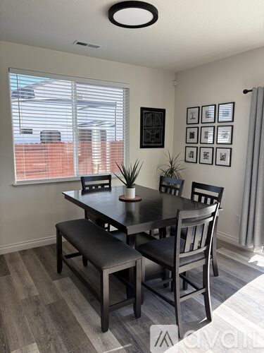 A dining room with a table and chairs.
