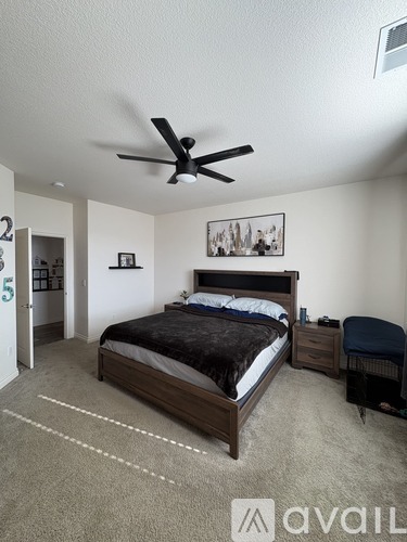 A bedroom with a bed, a chair, and a ceiling fan.