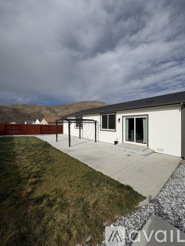 A modern house with a white exterior and a grey roof is shown.
