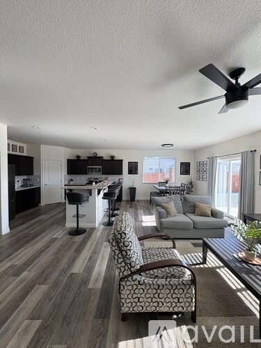 A living room with a grey couch and a black and white patterned chair.