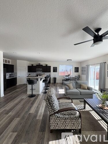 A living room with a grey couch and a black and white patterned chair.