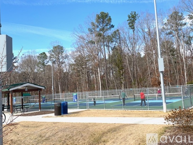 A playground with a blue trampoline and a brown gazebo.