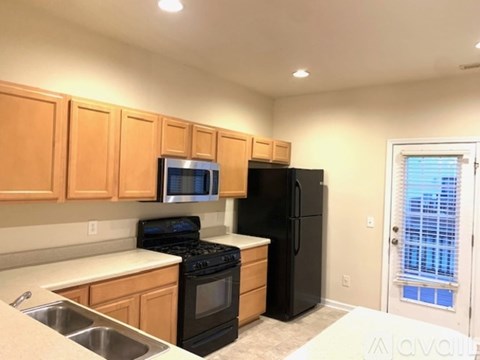 A kitchen with wooden cabinets and black appliances.