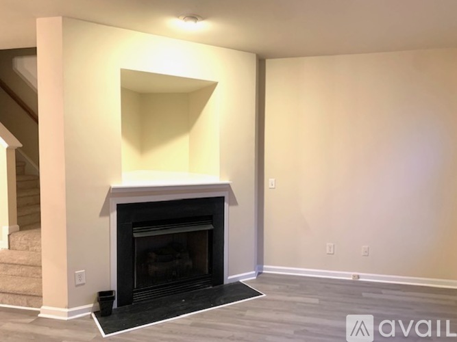 A living room with a fireplace and a staircase.