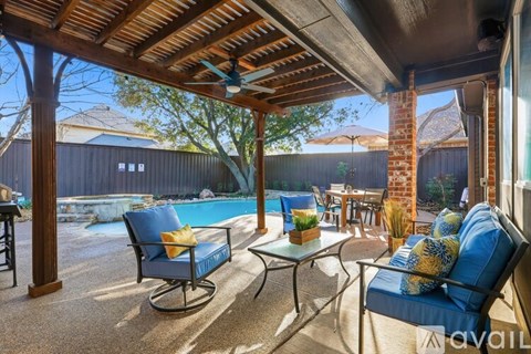 A patio with a table, chairs and a pool.